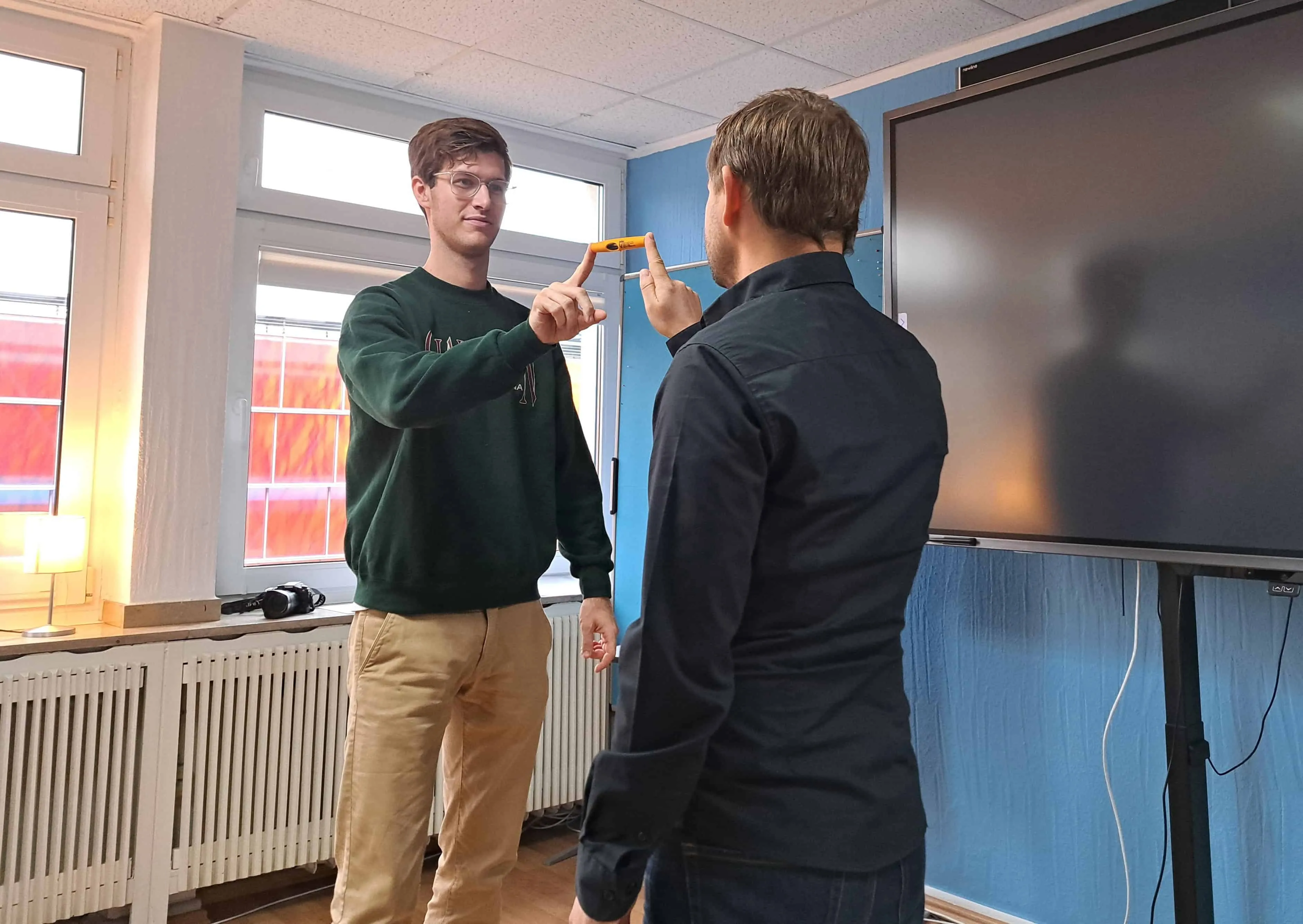 Fortbildung in einem Kollegium: Lehrkräfte im Gespräch mit einem Trainer im Klassenraum