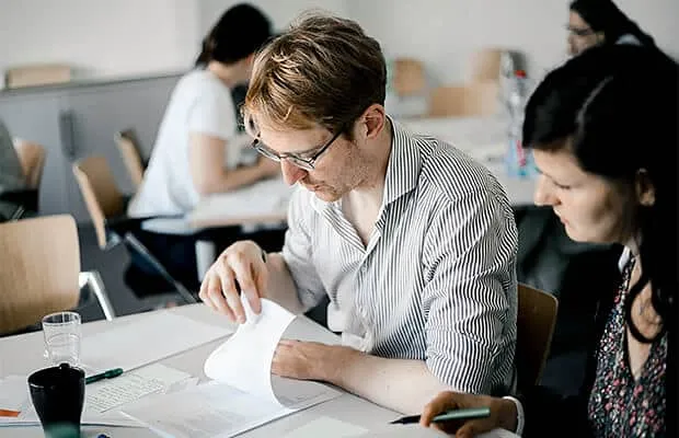 Lehrende arbeiten in einem Hochschul-Workshop an Texten